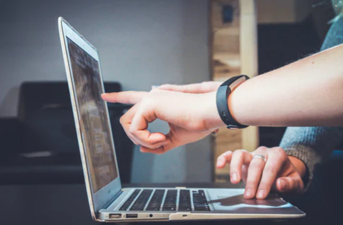 hands pointing at laptop